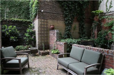 The private ground floor garden of 838 Greenwich Street makes picturesque use of the remains of a brick wall that once divided it in two. Credit. Tina Fineberg for The New York Times